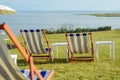 Empty beach chair on meadow on summer time. Sunlight and sea in the background