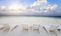 Empty beach chairs on sand by the sea at sunrise Royalty Free Stock Photo