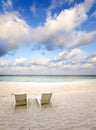 Empty beach chairs on sand by the sea at sunrise Royalty Free Stock Photo
