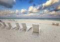 Empty beach chairs on sand by the sea at sunrise Royalty Free Stock Photo