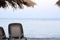 Empty beach chairs on sand at shoreline