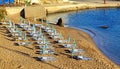 Empty beach chairs on sandy beach at reosrt Panormos in Crete island, Greece Royalty Free Stock Photo