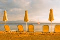 Empty beach chairs umbrella sun deck chairs beach lounge chair sea yacht beach sailboat sea shore sunset sail boat Royalty Free Stock Photo