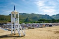 Beach umbrellas, chaise lounge and Lifeguard tower on the sand beach of Sperlonga