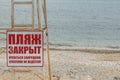 Empty beach in in cloudy weather. Sign in Russian, the beach is closed, swimming is prohibited. Feodosia. Crimea