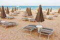 Empty beach with loungers and closed parasols Royalty Free Stock Photo