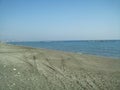 Empty beach of the Mediterranean coast in Limassol, Cyprus, in winter, in February. Crossing tire tracks in the sand Royalty Free Stock Photo