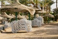 Empty beach with palm, white sunbeds, wicker umbrellas waiting for new summer holiday season tourists. Abandoned Royalty Free Stock Photo