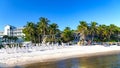Empty beach resort with white sand and palm trees under blue sky Royalty Free Stock Photo