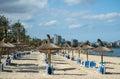 Empty beach with straw umbrellas under a bright blue sky