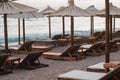 Empty beach with sun beds and straw umbrellas by the sea Royalty Free Stock Photo