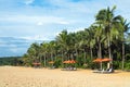 Empty beach with umbrellas and deck chairs. Palm trees. Beautiful summertime view seascape. Relax places island Bali island,