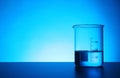 Empty beaker on table against color background. Chemistry laboratory