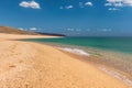 Empty beautiful soft golden sandy beach and sea. Isolated beach, no people. Dry sunny daytime image, where gold sand meets sea and