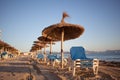 Empty beaxh with straw umbrellas on sunrise Royalty Free Stock Photo