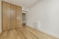 Empty bedroom with custom built built-in wardrobe with light oak wooden doors, ducted air conditioning on the ceiling, white Royalty Free Stock Photo