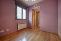 Empty bedroom with fuchsia painted walls, an antechamber with a sliding-door wardrobe, and access to an en-suite bathroom