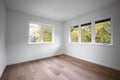 Empty bedroom with wooden floors and several windows allowing natural light Royalty Free Stock Photo