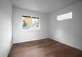 Empty bedroom with wooden floors and several windows allowing natural light Royalty Free Stock Photo