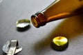 Empty beer bottle opener and gold bottle caps Royalty Free Stock Photo