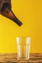 Empty beer glass, bottle beer on a wooden background and yellow, selective focus. Royalty Free Stock Photo