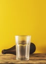 Empty beer glass, bottle beer on a wooden background and yellow, selective focus. Royalty Free Stock Photo