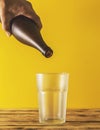 Empty beer glass, bottle beer on a wooden background and yellow, selective focus. Royalty Free Stock Photo