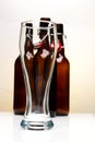 Empty beer glass with beer bottles on white background Royalty Free Stock Photo