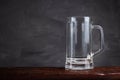 An empty beer glass stands on a wooden table Royalty Free Stock Photo