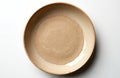 Empty beige ceramic dish with rough sandy texture at bottom center. Simple clean background, top view, isolated object. Rustic Royalty Free Stock Photo
