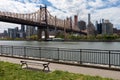 Queensbridge Park along the East River with the Queensboro Bridge and an Empty Bench during Spring in Long Island City Queens New Royalty Free Stock Photo