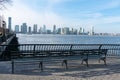 Empty Bench at Battery Park in New York City with a view of the Jersey City Skyline along the Hudson River Royalty Free Stock Photo