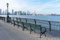Empty Bench at Battery Park in New York City with a view of the Jersey City Skyline along the Hudson River Royalty Free Stock Photo