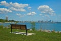 An empty bench faces Downtown Milwaukee across a Lake Michigan harbor in Summer.. Royalty Free Stock Photo