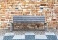 An empty bench in front of a stone wall. Royalty Free Stock Photo
