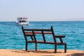 Empty bench near sea and shipped ship. Mass tourism at sea. Bench near beach