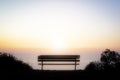 Empty bench overlooking the colorful light of sunset over the ho Royalty Free Stock Photo