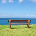 Empty bench overlooking the ocean on a sunny day with copyspace. Wooden seat to sit and reflect, with therapeutic views Royalty Free Stock Photo