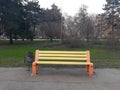 An empty bench in the park, painted in yellow and red Royalty Free Stock Photo