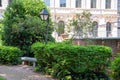 Empty bench in Philadelphia city park with shrubs and red brick Royalty Free Stock Photo