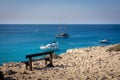 Empty bench at the seaside. Blue Lagoon, Cape Greco, Cyprus. Royalty Free Stock Photo