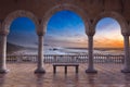 3D illustration and photo composite of a large terrace with an empty bench seat, stone arches and columns