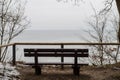 Empty bench on the shore of the ocean on a winter day Royalty Free Stock Photo