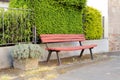 An empty bench on the sidewalk next to a street Royalty Free Stock Photo