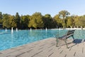 An empty bench and a view of the bright blue water of a Singing fountain in the central city park of Plovdiv. Bulgaria Royalty Free Stock Photo