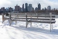 Empty Benches at Rainey Park in Astoria Queens Covered in Snow during Winter along the East River with the New York City Skyline