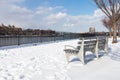 Empty Benches at Rainey Park in Astoria Queens Covered in Snow during Winter along the East River with the New York City Skyline