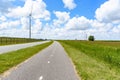 Empty bicycle path in the countryside of Netherlands. Wind turbines are visible in distance. Royalty Free Stock Photo