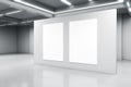 Empty big white room with a white concrete wall with two blank posters in the middle, artificially lighted, art gallery and Royalty Free Stock Photo