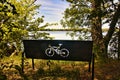 An empty bike bench faces the calm waters of the Chippewa River along a recreational trail in Wisconsin